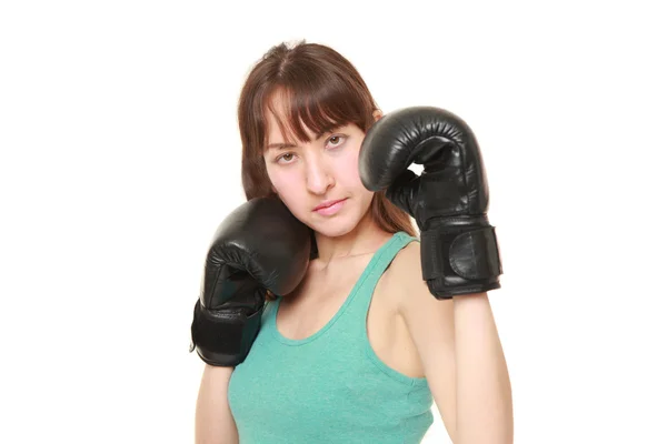 Pugile femminile con pugni glovesthrow su una posizione di combattimento — Foto Stock
