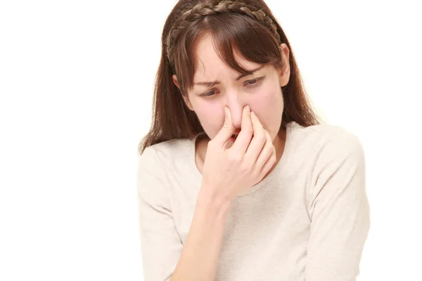 Mujer sosteniendo su nariz debido a un mal olor — Foto de Stock