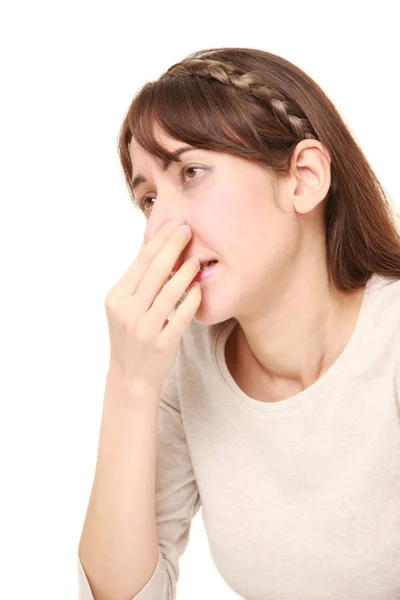 Mujer sosteniendo su nariz debido a un mal olor — Foto de Stock