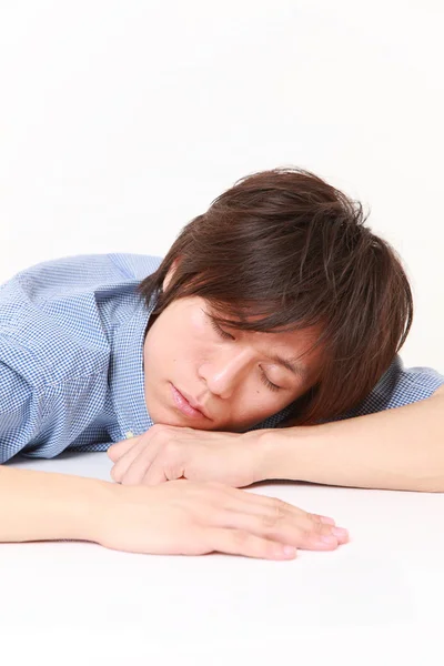 Joven durmiendo sobre la mesa — Foto de Stock