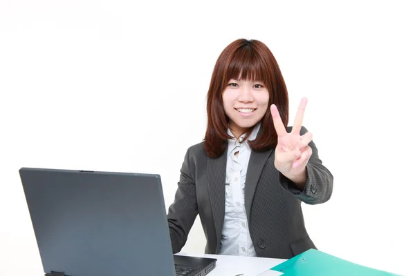 Jonge Japanse zakenvrouw met een teken van de overwinning — Stockfoto