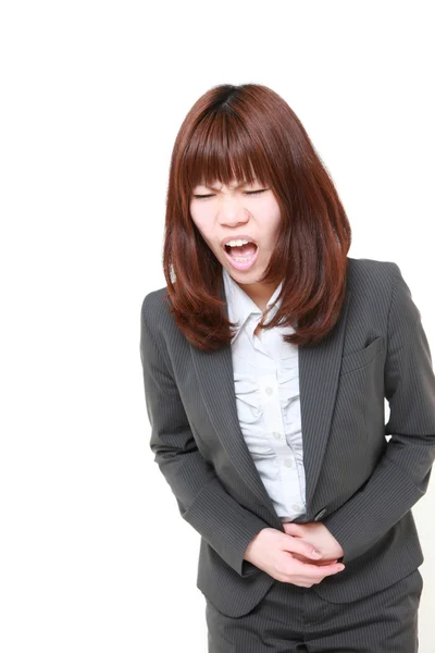 Young Japanese businesswoman suffers from stomachache — Stock Photo, Image