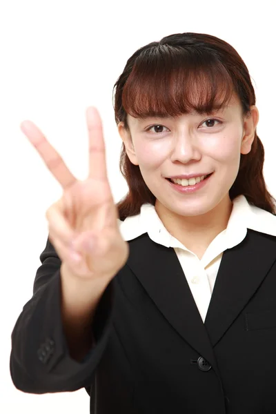 Onaantrekkelijk Aziatische zakenvrouw met een teken van de overwinning — Stockfoto