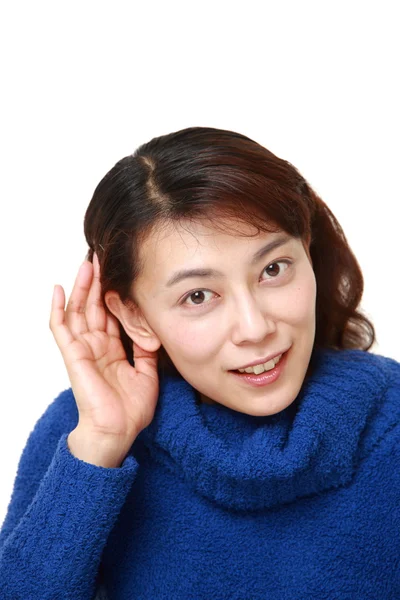 Mujer con la mano detrás de la oreja escuchando atentamente — Foto de Stock