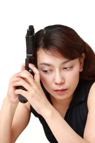 Woman with a handgun thinks — Stock Photo, Image