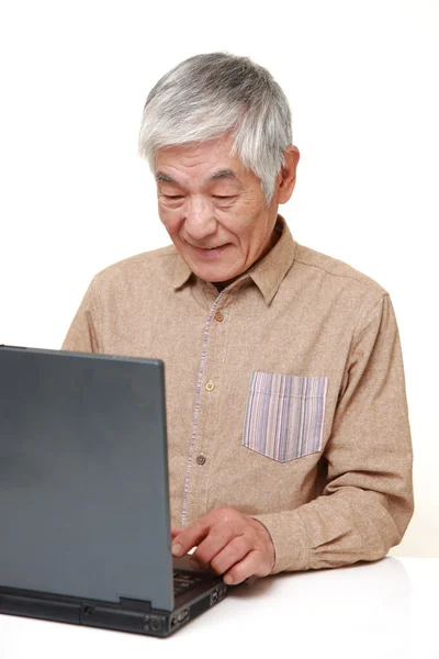 Starszy człowiek japoński za pomocą komputera przenośnego — Zdjęcie stockowe