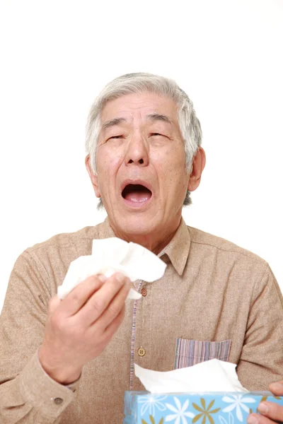 Senior Japanese man with an allergy sneezing into tissue — Stock Photo, Image