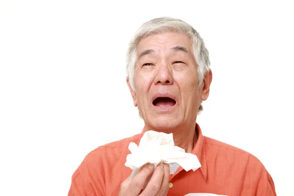 Senior Japanese man with an allergy sneezing into tissue — Stock Photo, Image