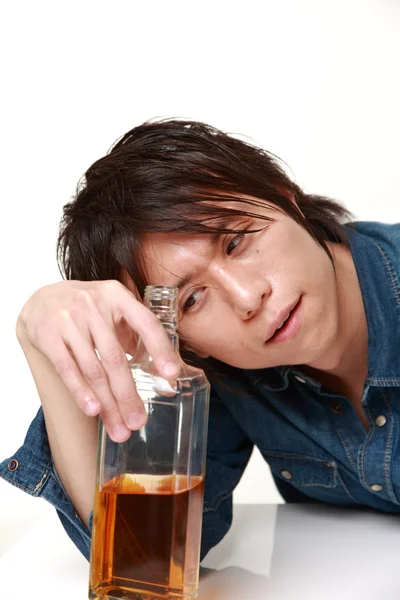 Jonge Japanse man drinken rechtstreeks uit een fles — Stockfoto