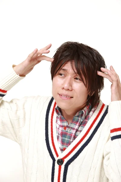 Joven japonés hombre sufre de dolor de cabeza — Foto de Stock