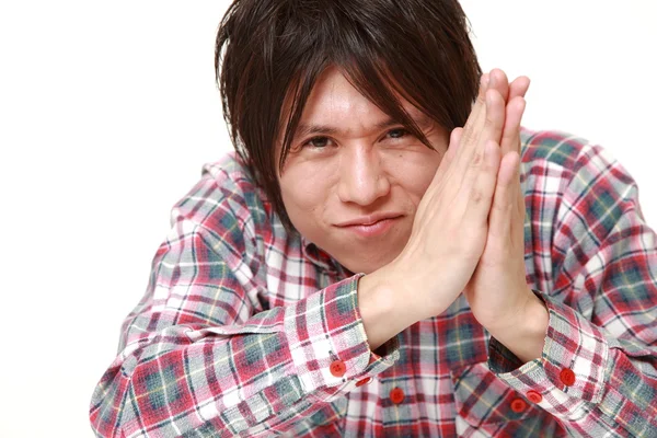 Молодой японский мужчина, сложив руки в молитве — стоковое фото