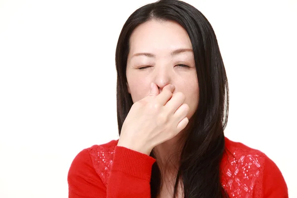 Japonesa mujer sosteniendo su nariz debido a un mal olor —  Fotos de Stock