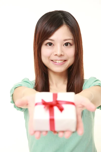 Jovem mulher japonesa oferecendo um presente — Fotografia de Stock