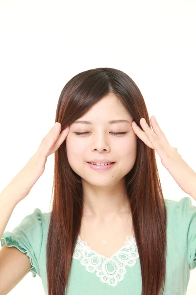 Joven japonesa mujer haciendo uno mismo cabeza masaje — Foto de Stock