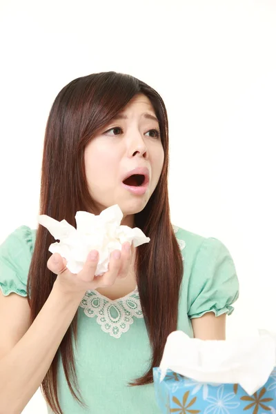 Молодая женщина с аллергией чихает в ткани — стоковое фото