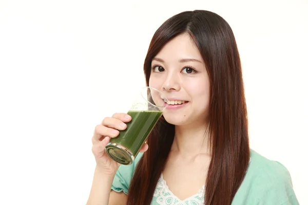 Young Japanese woman with green vegetable juice — Stock Photo, Image