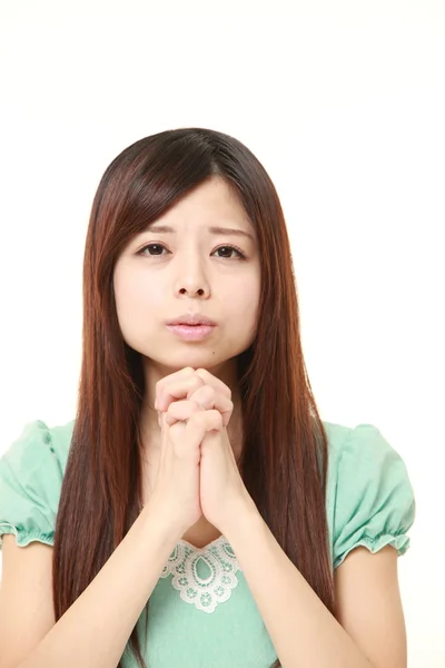 Kvinna fällbara hennes händer i bön — Stockfoto