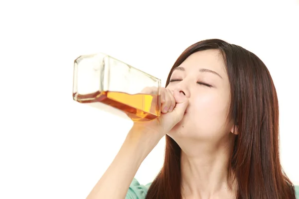 Jeune femme japonaise boire directement à partir d'une bouteille — Photo