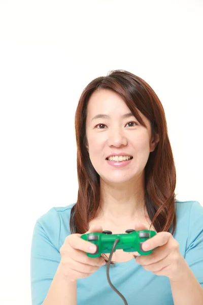 Mulher japonesa de meia idade desfrutando de um jogo de vídeo — Fotografia de Stock