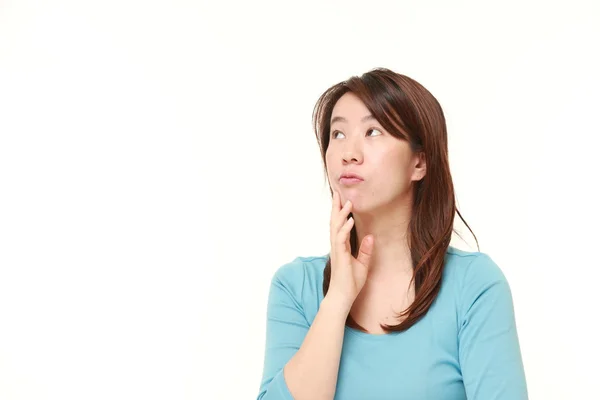 Middle aged Japanese woman thinks about something — Stock Photo, Image