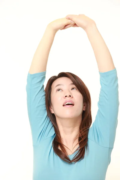 Mellersta åldern japansk kvinna gör stretch — Stockfoto