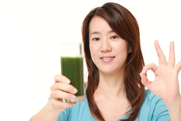 Middle aged Japanese woman with green vegetable juice — Stock Photo, Image