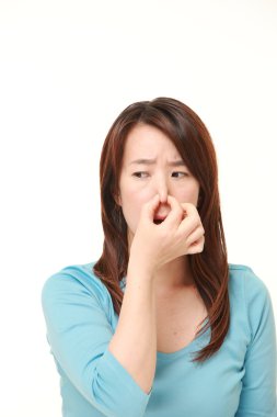 kötü bir koku yüzünden burnunu tutan orta yaşlı Japon kadın
