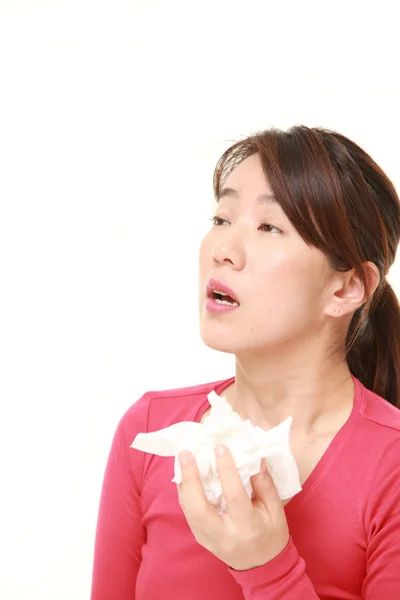 Middle aged woman with an allergy sneezing into tissue — Stock Photo, Image