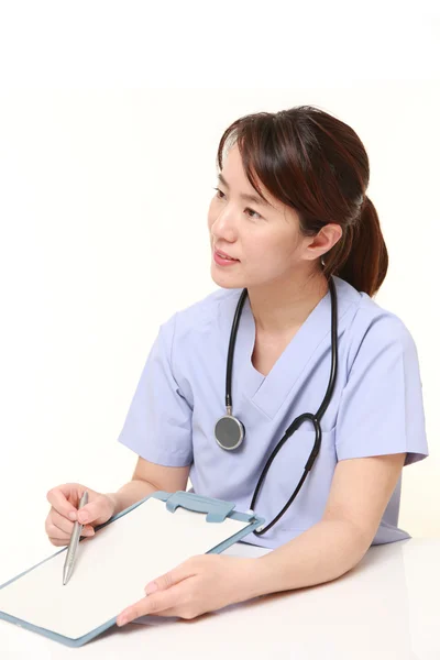 Japanese female doctor with clinical record talks to her patient — Stock Photo, Image