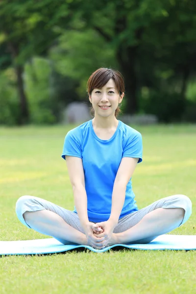 Japanese woman outside doing stretches exercise — Stock Photo, Image