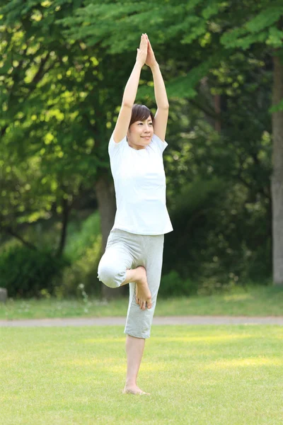 Японская женщина на улице позирует на дереве йоги — стоковое фото