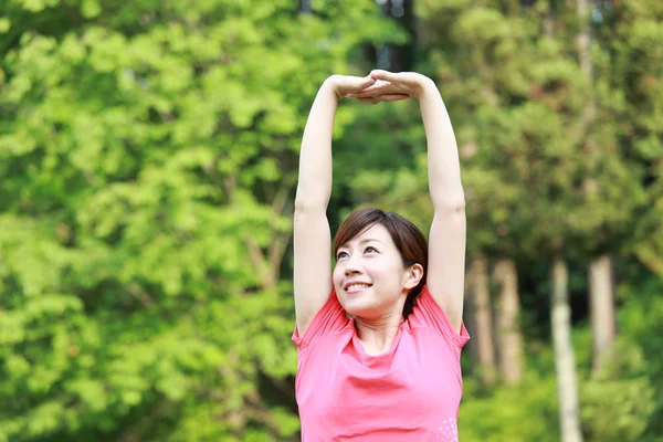 Japonesa mujer fuera haciendo estiramientos ejercicio —  Fotos de Stock