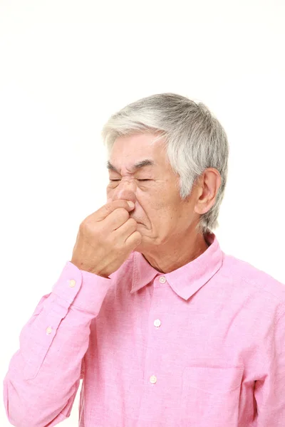 Senior Japanese man holding his nose because of a bad smell — Stock Photo, Image