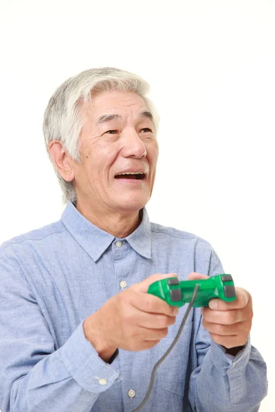 Senior japonés hombre disfrutando de un video juego —  Fotos de Stock