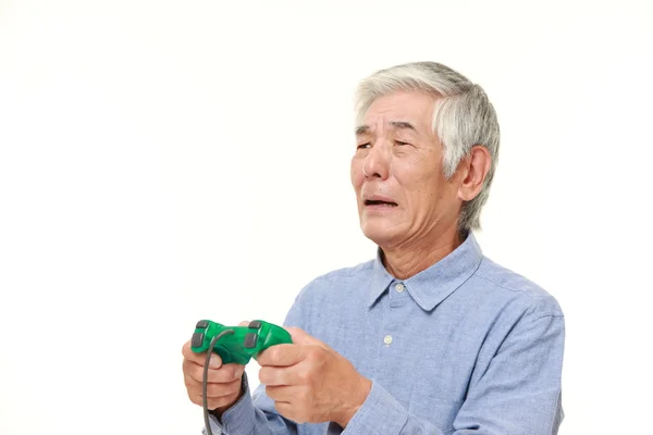 Senior japansk man förlorar spela video spel — Stockfoto