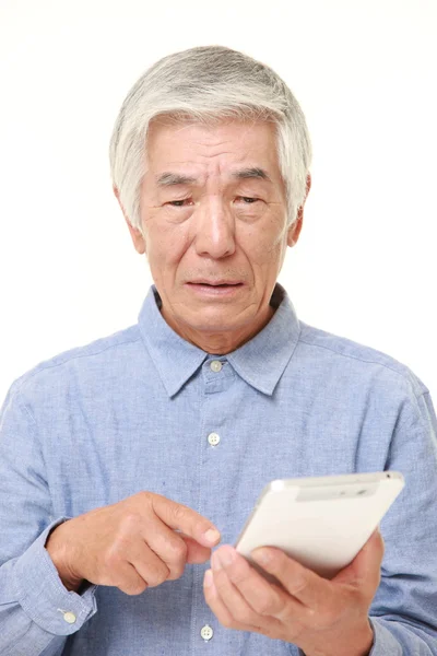Sênior japonês homem usando tablet computador olhando confuso — Fotografia de Stock