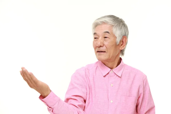 Senior japonés hombre presentando y mostrando algo — Foto de Stock