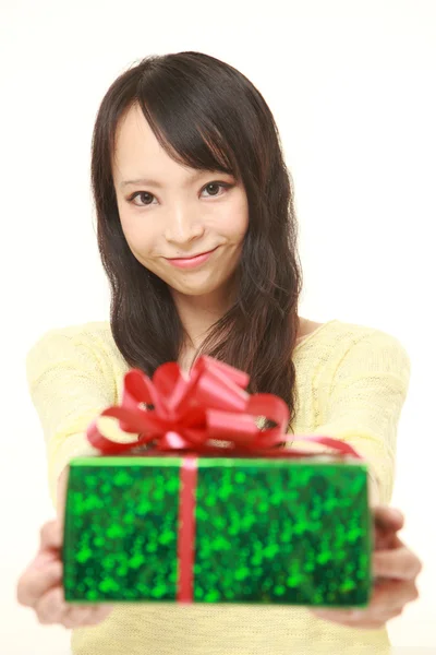 Jovem mulher japonesa oferecendo um presente — Fotografia de Stock