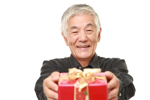 Üst düzey Japon adam bir hediye sunuyor — Stok fotoğraf
