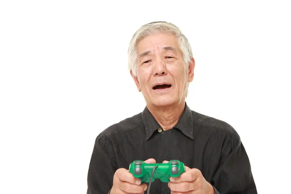 Senior japansk man förlorar spela video spel — Stockfoto