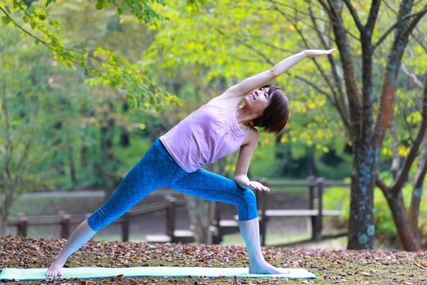 日本女人外面做瑜伽三角伸展式 — 图库照片