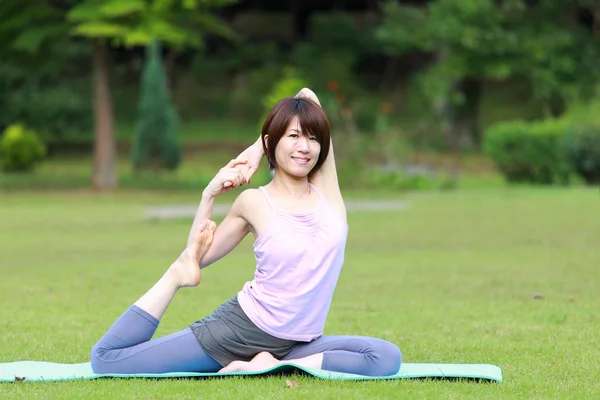 日本女性外ヨガ脚王鳩のポーズ — ストック写真