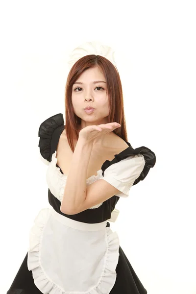 Joven japonesa mujer vistiendo francés sirvienta traje soplando un beso —  Fotos de Stock
