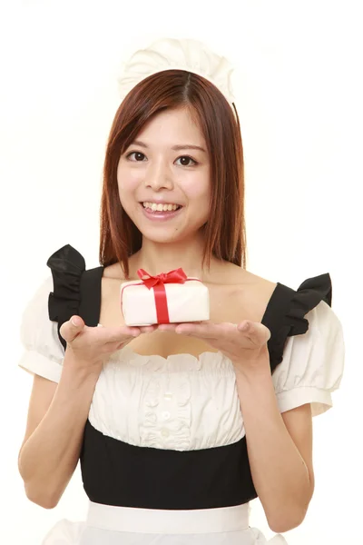 Νέα ιαπωνική γυναίκα που φοράει Γαλλικά καμαριέρα κοστούμι προσφέροντας ένα δώρο — Φωτογραφία Αρχείου