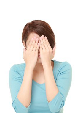 genç bir kadın yüzüne elle kapsayan