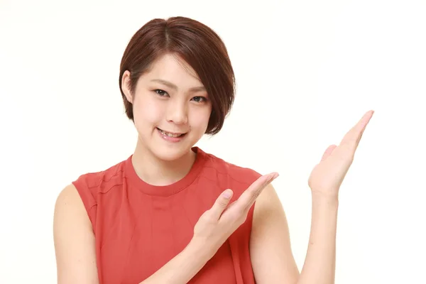 Young Japanese woman presenting and showing something — Stock Photo, Image