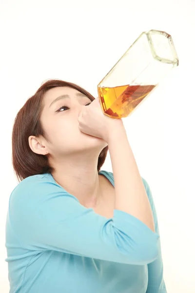 Jonge Japanse vrouw drinken rechtstreeks uit een fles — Stockfoto