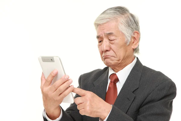 Senior japonés hombre de negocios usando tableta ordenador buscando confundido —  Fotos de Stock