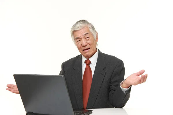 Empresário japonês sênior usando computador parecendo confuso — Fotografia de Stock