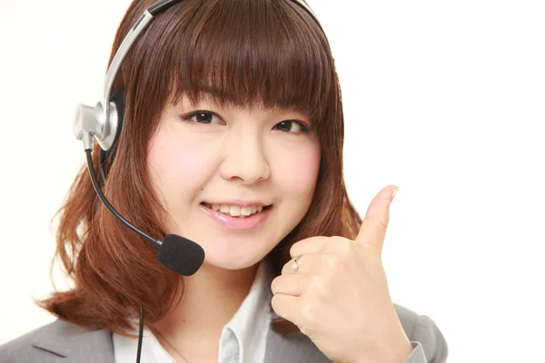 Jonge Japanse zakenvrouw van callcenter met hoofdreeksen met duimen omhoog gebaar — Stockfoto